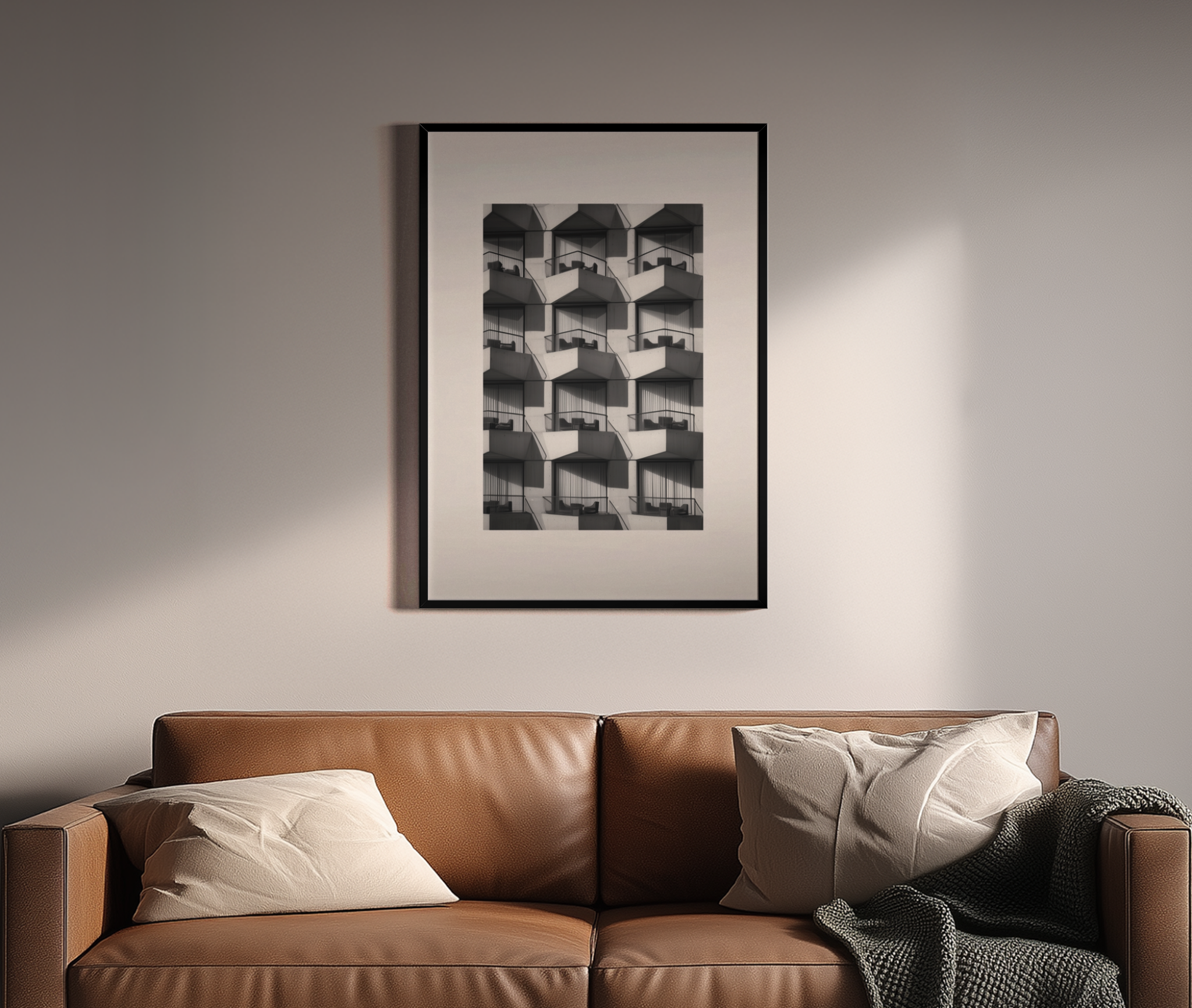 Repetitive Balkonfassade in Schwarz-Weiß Fotografie – Brutalismus Wandbild über braunem Ledersofa