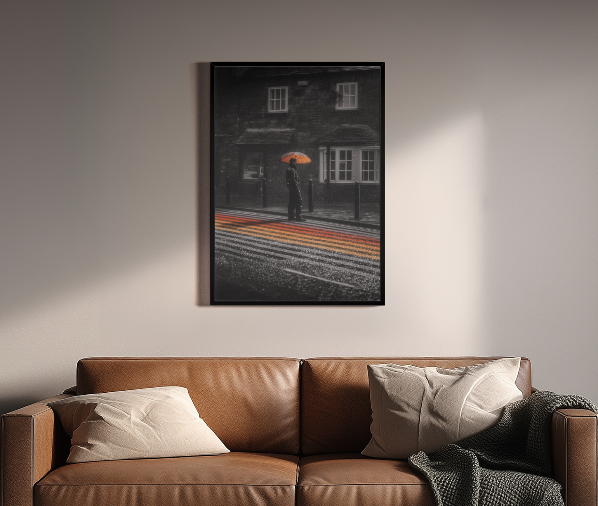 Schwarz-Weiß Fotografie mit orangem Regenschirm und buntem Zebrastreifen im Regen – Wandbild über braunem Ledersofa